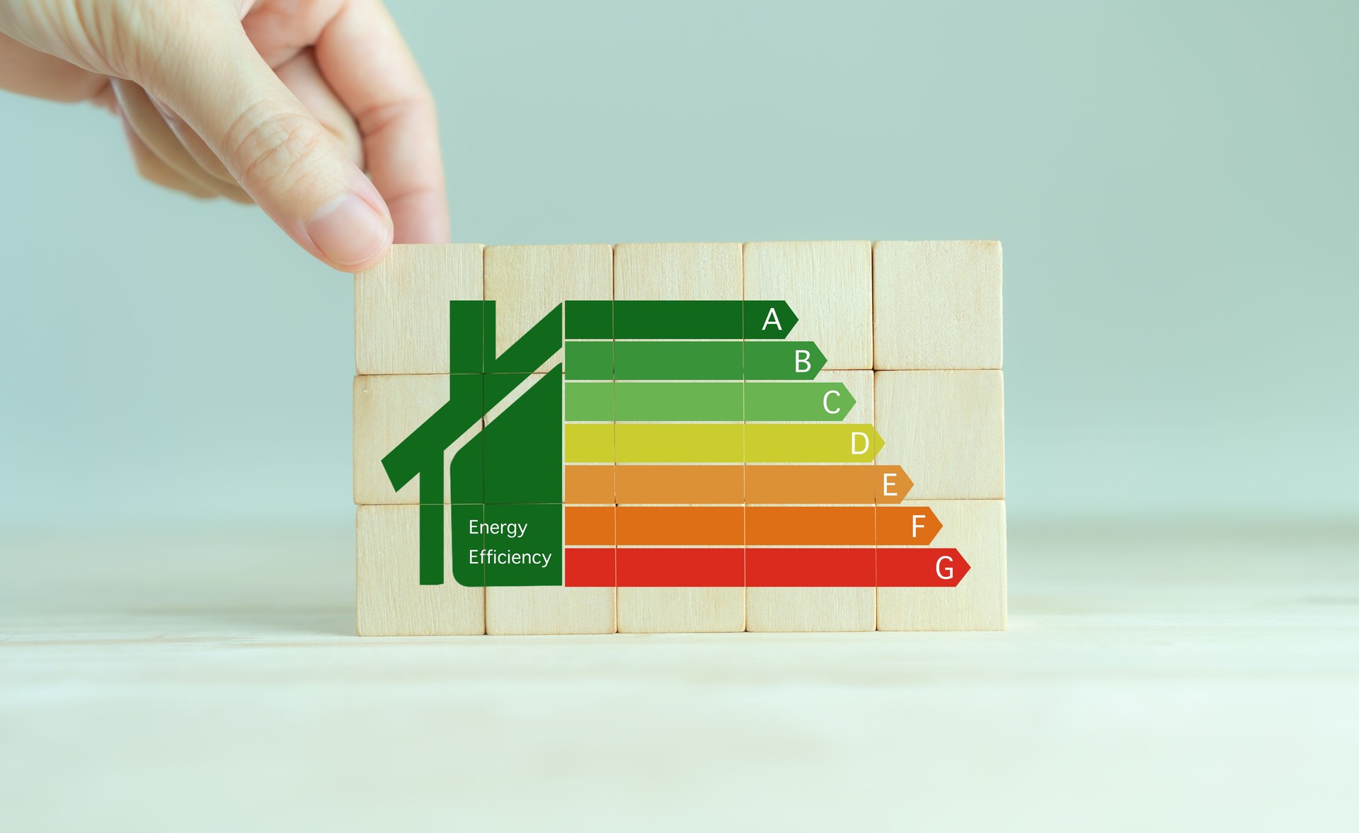Energy efficiency and home improvement concept. Ecological and bio energetic house. Energy class;house efficiency rating. Low energy to save money. Hand holds wooden cubes with energy efficiency scale